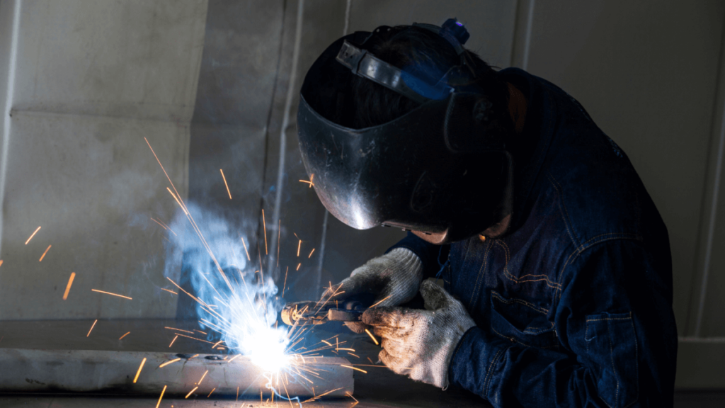 Worker welding and working on welding defects