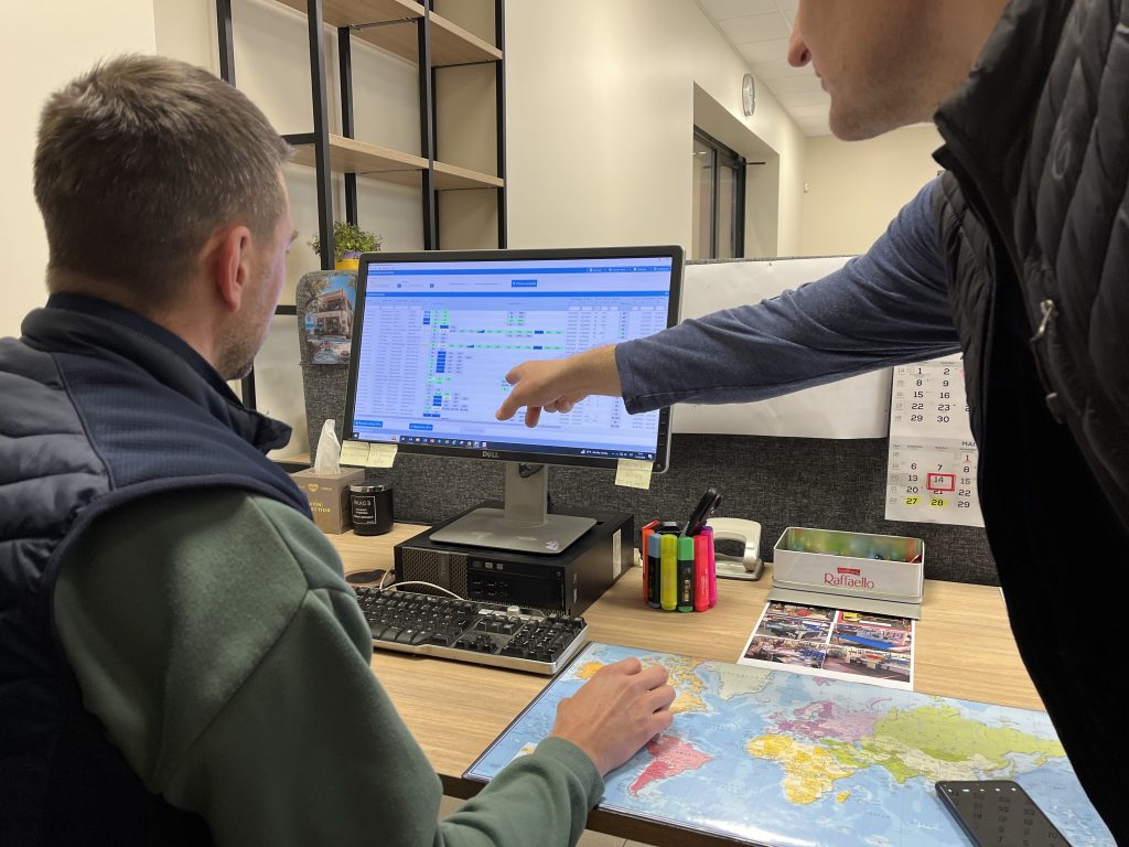 Steel fabrication shop supervisor checking real-time job status in production tracking software on desktop